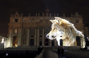 A picture of a wolf, part of an art projection featuring images of humanity and climate change artistically rendered by Obscura Digital, is projected onto the facade of St. Peter's Basilica, as part of an installation entitled "Fiat Lux: Illuminating our Common Home" as a gift to Pope Francis on the opening day of the Extraordinary Jubilee, at the Vatican, December 8, 2015. REUTERS/Stefano Rellandini FOR EDITORIAL USE ONLY. NO RESALES. NO ARCHIVE.